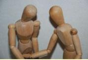 Bild zeigt zwei Figuren aus Holz die einander zugewendet sind